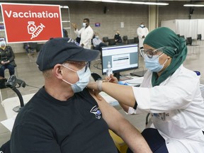 A man receives his COVID-19 vaccine at Montreal's Olympic Stadium on Tuesday, February 23, 2021.