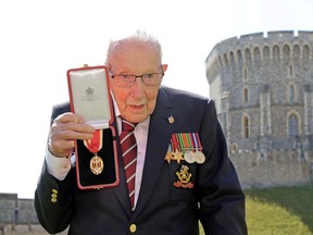 FILE PHOTO: Captain Tom Moore poses after being awarded with the insignia of Knight Bachelor by Britain's Queen Elizabeth at Windsor Castle, in Windsor, Britain July 17, 2020.