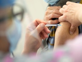 People register to receive their first dose of COVID-19 vaccination in Laval on Feb. 25, marking the start of mass vaccination in Quebec.