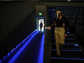 A worker disinfects a movie theatre in Santiago, Chile this month. In Montreal, cinemas will be open as of Feb. 26, although distancing and other measures will be in effect.