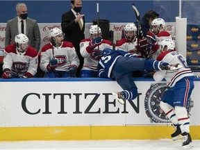 Canadiens' Shea Weber (6) checks Toronto Maple Leafs' Alexander Kerfoot (15) into the Montreal bench during the second period at Scotiabank Arena in Toronto on Saturday, Feb. 13, 2021.