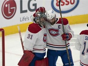Goalie Carey Price is congratulated by captain Shea Weber after making 21 saves in 2-1 win over the Maple Leafs Saturday night in Toronto, improving his record to 5-2-0 with a 2.64 goals-against average and a .901 save percentage.