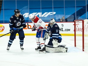 Winnipeg Jets goalie Connor Hellebuyck (37) makes a save despite being screened by Montreal Canadiens forward Brendan Gallagher (11) during the first period at Bell MTS Place. Mandatory Credit: Terrence Lee-USA TODAY Sports