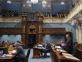 Quebec Premier François Legault, right, offers his season's greetings in a more than half-empty "salon bleu" after question period Friday, Dec. 11, 2020, at the legislature in Quebec City.