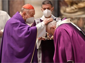 Pope Francis is sprinkled with ashes by a cardinal during the Ash Wednesday mass at St. Peter's Basilica at the Vatican, February 17, 2021. Vatican Media/Handout via REUTERS   ATTENTION EDITORS - THIS IMAGE WAS PROVIDED BY A THIRD PARTY.