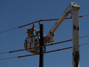 Workers install a utility pole to support power lines after an unprecedented winter storm in Houston, Texas, U.S., Feb. 22, 2021.