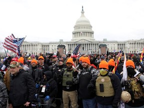 FILE PHOTO: Members of the far-right group Proud Boys make 'OK' hand gestures indicating "white power" as supporters of U.S. President Donald Trump gather in front of the U.S. Capitol Building to protest against the certification of the 2020 U.S. presidential election results by the U.S. Congress, in Washington, U.S., January 6, 2021.