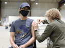 A health-care worker administers a COVID-19 vaccine.