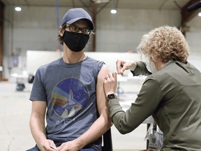 A health-care worker administers a COVID-19 vaccine. Local health authorities are setting up mass vaccination sites across Montreal.