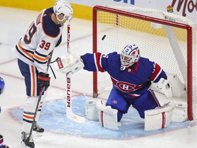 Montreal Canadiens' Jake Allen makes a save with Edmonton Oilers' Alex Chiasson looking for a rebound during the third period of a National Hockey League game in Montreal Feb. 11, 2021.