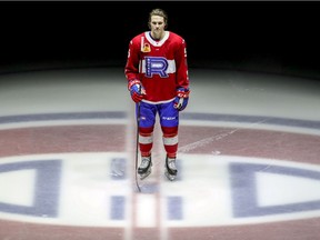 Laval Rocket's Cale Fleury stands at centre ice during ceremony prior to the team's opening American Hockey League game of the season against the Belleville Senators at the Bell Centre in Montreal on Feb. 12, 2021.