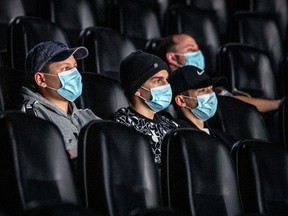 Mask-wearing movie-goers watch The Lord Of The Rings: The Fellowship of the Ring at the Cinéma Banque Scotia in Montreal Friday Feb. 26, 2021, the first day for movie theatres to be open following the provincial government's most recent loosening of some COVID-19 regulations.