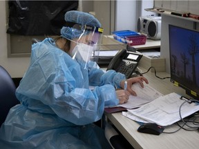 A nurse fills out her medical notes in the nurse's station inside the COVID-19 unit of the Verdun Hospital in Montreal on Tuesday, Feb. 16, 2021.