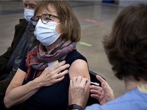 Jocelyne Lefebvre receives her COVID-19 vaccine at the vaccination centre setup inside the Palais des congrès, in Montreal, on Monday, March 1, 2021.