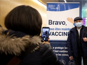 A man has his picture taken by a family member after being vaccinated at the vaccination centre at the Palais des congrès on Monday, March 1, 2021.