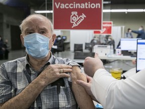 Emilien Mainville receives his first shot of COVID-19 vaccine by nurse Chad Gherbaz at the Olympic Stadium on Monday March 1, 2021 during the first day of mass vaccination in Montreal.