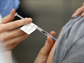 A healthcare worker administers the Covid-19 vaccination at the vaccination centre setup inside the Palais des congres on March 1, 2021.