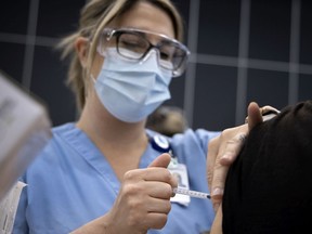 A healthcare worker administers the Covid-19 vaccination at the vaccination centre set up inside the Palais des congres on March 1, 2021.