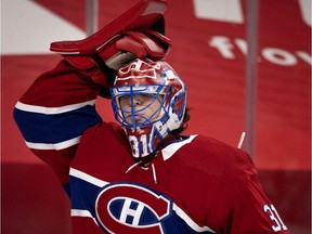 Montreal Canadiens goaltender Carey Price adjusts his mask after drinking water during a break in action against the Ottawa Senators in Montreal on March 2, 2021.