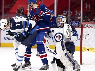 Montreal Canadiens left wing Jonathan Drouin's shot sails past Winnipeg Jets goaltender Connor Hellebuyck to tie the game 3-3 in the final moments of the third period in Montreal on Thursday, March 4, 2021.