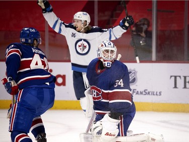 Winnipeg Jets left wing Kyle Connor celebrates as Montreal Canadiens goaltender Jake Allen looks back in to the net after the Winnipeg Jets scored the winning goal in overtime in Montreal on Thursday, March 4, 2021.