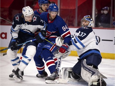 Montreal Canadiens right wing Corey Perry is squeezed between Winnipeg Jets defenseman Tucker Poolman and Winnipeg Jets goaltender Connor Hellebuyck in the first period at the Bell Centre on Thursday, March 4, 2021.