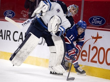 Winnipeg Jets goaltender Connor Hellebuyck leans on Montreal Canadiens right wing Brendan Gallagher as Gallagher tries to squeeze behind him in the first period at the Bell Centre on Thursday, March 4, 2021.