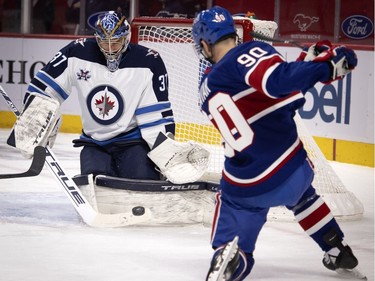 Winnipeg Jets goaltender Connor Hellebuyck stops a shot by Montreal Canadiens left wing Tomas Tatar in the first period at the Bell Centre on Thursday, March 4, 2021.