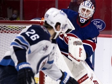 Montreal Canadiens goaltender Jake Allen plays the puck past Winnipeg Jets right wing Blake Wheeler during second period in Montreal on Thursday, March 4, 2021.