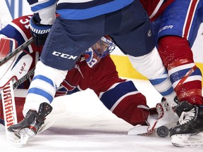 Canadiens goalie Carey Price reaches between legs in his crease to cover the puck during game against the Winnipeg Jets Saturday night at the Bell Centre.