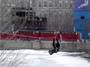 MONTREAL, QUE.: March 14, 2021 -- Sonja Lessard braves the cold and the wind to ride the 90 foot high zip line in the Old Port of Montreal, on Sunday, March 14, 2021.