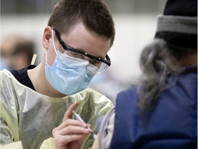 A health worker administers a COVID-19 vaccination at the Bill Durnan Arena in C.D.N. on Wednesday, March 10, 2021. There are reports of small numbers of people turning up for  vaccinations at the site.