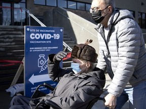 An elderly man in a wheelchair arrives at the Bill Durnan Arena to receive his COVID-19 vaccination in Côte-des-Neiges on Wednesday, March 10, 2021.