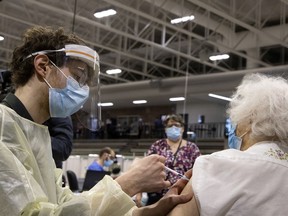 A health-care worker administers a COVID-19 vaccine to Marion Locke, 97, at the Bill Durnan Arena in March.