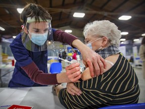 Physiotherapist Linda Coulombe vaccinates Kathleen St-Germain at vaccination clinic at Bob Birnie Arena in Pointe Claire on Monday March 8, 2021.