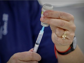 A syringe is filled with vaccine at COVID-19 mass vaccination clinic at Bob Birnie Arena in the Pointe Claire suburb of Montreal Monday March 8, 2021.