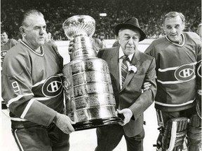 Former head coach of the Canadiens Hector (Toe) Blake, centre, gets helping hand from Maurice (Rocket) Richard, left, and Jacques Plante carrying the Stanley Cup on Forum ice on Dec. 17, 1983.