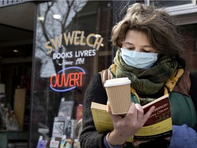 Caroline Segal reads during a "read-in" protest to symbolize opposition to predatory landlords, outside S.W. Welch Bookstore, in Montreal, on March 13, 2021.