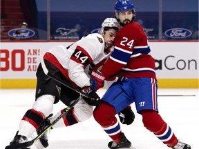 Ottawa Senators defenceman Erik Gudbranson (44) grimaces as he takes a hit from Montreal Canadiens left wing Phillip Danault (24) during NHL action in Montreal on Tuesday, March 2, 2021.