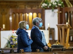 Claude Bergeron and Marie-Margarite Houde pray the Stations of the Cross in the crypt church at Saint Joseph's Oratory after it reopened in Montreal Friday March 26, 2021.