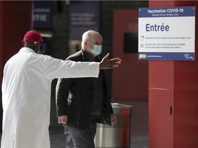 A Montrealer is guided toward the entrance of the Olympic Stadium vaccination centre on Monday March 29, 2021 for his COVID-19 vaccine.