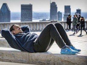 Nacim Louali does crunches while working out at the look-out on Mount Royal in Montreal on March 30, 2021.