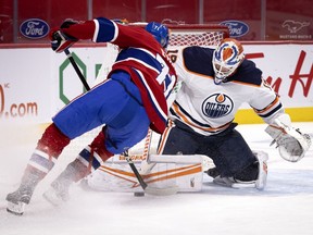 Oilers goalie Mikko Koskinen makes save against Canadiens centre Jake Evans during Tuesday night’s game at the Bell Centre.