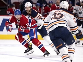 Canadiens' Jesperi Kotkaniemi carries the puck over the blue line under pressure from Oilers' Darnell Nurse  and Tyson Barrie Tuesday night at the Bell Centre.