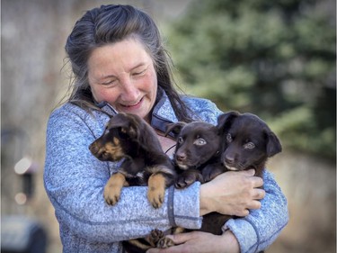 Helen Lacroix, founder of Animatch adoption service, with puppies at her home in Pointe Fortune.