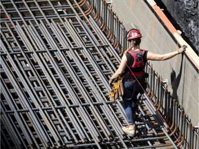 A female construction worker installs rebar on a new condo project in Montreal, on Wednesday, August 12, 2020.