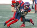 Montreal Alouettes receiver Quan Bray is tackled by Calgary Stampeders' Nate Holley during a game in Montreal on Oct. 5, 2019. 