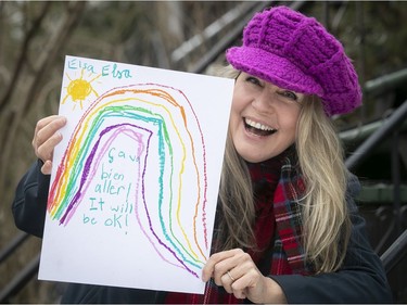 Documentary filmmaker Bobbi Jo Hart holds  a drawing of a rainbow drawn by a  child, with the tagline "Ça va bien aller" on Dec. 10, 2020.