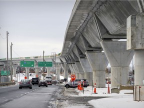Cars pass under the REM train tracks in Kirkland, west of Montreal Thursday December 10, 2020. "The REM must be forced to sit down and plan with other transit providers — even if it’s just to avoid cannibalizing existing transit routes or to temper their enthusiasm for erecting concrete megaliths reminiscent of Stonehenge," Peter F. Trent writes.