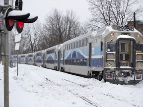 An AMT commuter train waits to leave the scene after colliding with car at a level crossing on Gouin Boulevard in Montreal, on Tuesday, February 18, 2020.